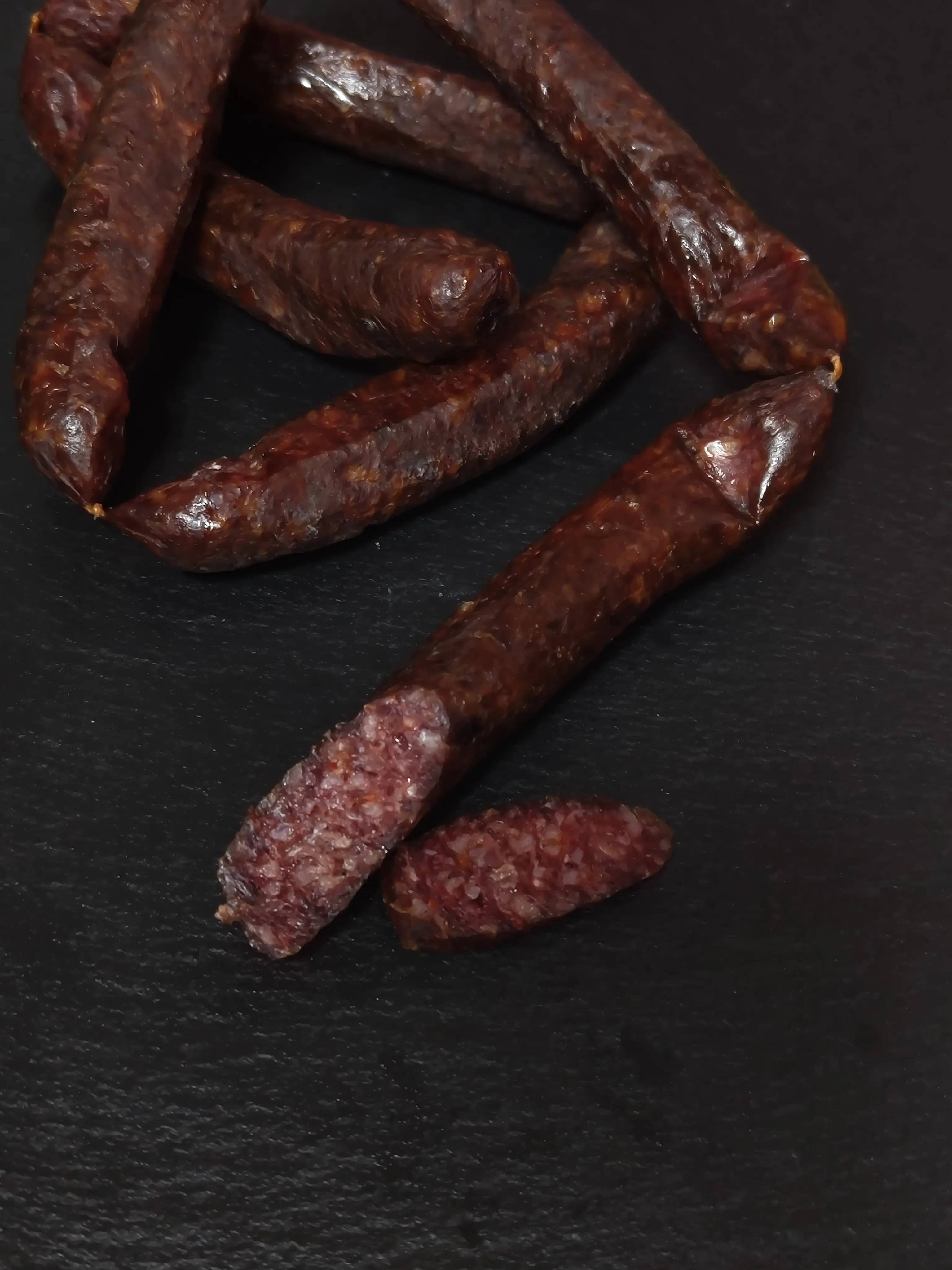 Selbstgefertigte Hirschboxerl zum Jausnen auf einer schwarzen Schieferplatte in Szene gesetzt